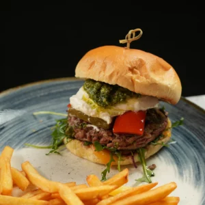 Burger provençal servi à L’AGRICOLE Nevers avec steak haché frais, burrata, pesto maison et cheddar rouge