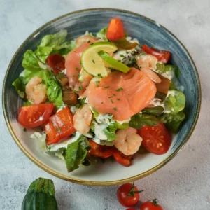 Salade nordique servie à L’AGRICOLE Nevers avec saumon fumé, crevettes, tomates et sauce citronnée maison
